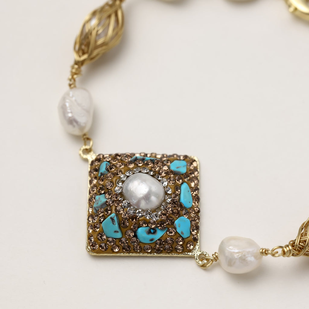 Ornate gold-plated bracelet with square turquoise and crystal centerpiece, freshwater pearls, and decorative chain links