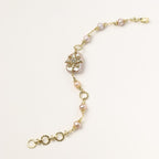 Gold-plated chain bracelet with baroque pearl centerpiece and floral charm, featuring mixed freshwater pearls.