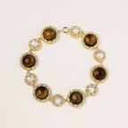 Ornate gold-plated bracelet with alternating brown tiger's eye stones and white freshwater pearls in crystal-accented settings