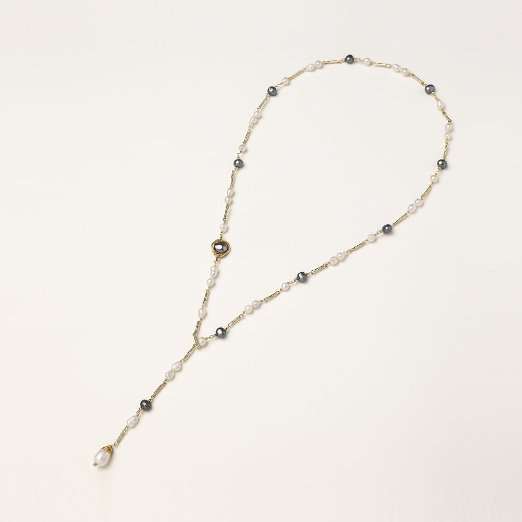 Long gold-plated necklace with alternating white and gray freshwater pearls spaced along delicate chain segments