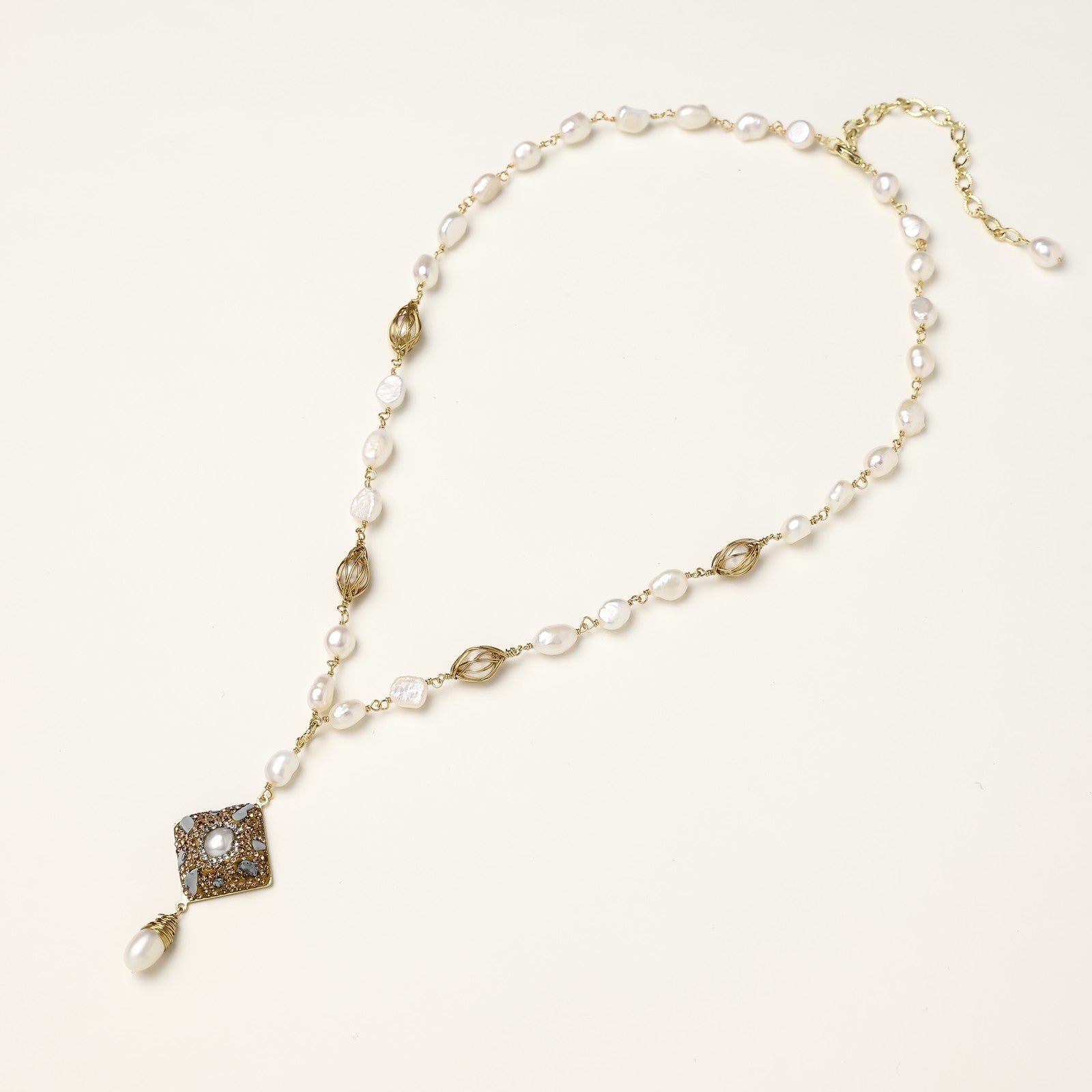 Elegant 14K gold plated necklace with freshwater pearls and ornate crystal diamond pendant on cream background.
