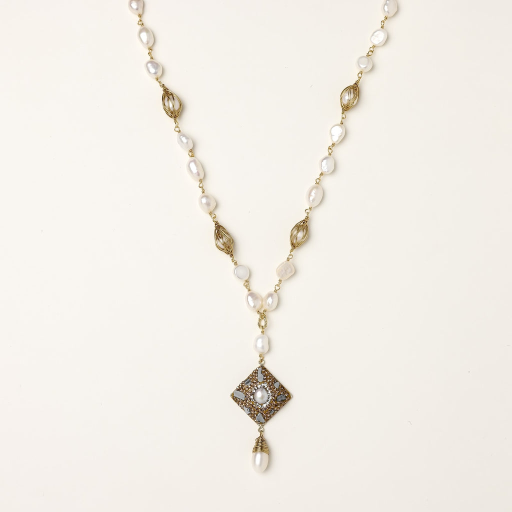 Elegant 14K gold plated necklace with freshwater pearls and ornate crystal diamond pendant on cream background.