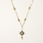 Elegant 14K gold plated necklace with freshwater pearls and ornate crystal diamond pendant on cream background.