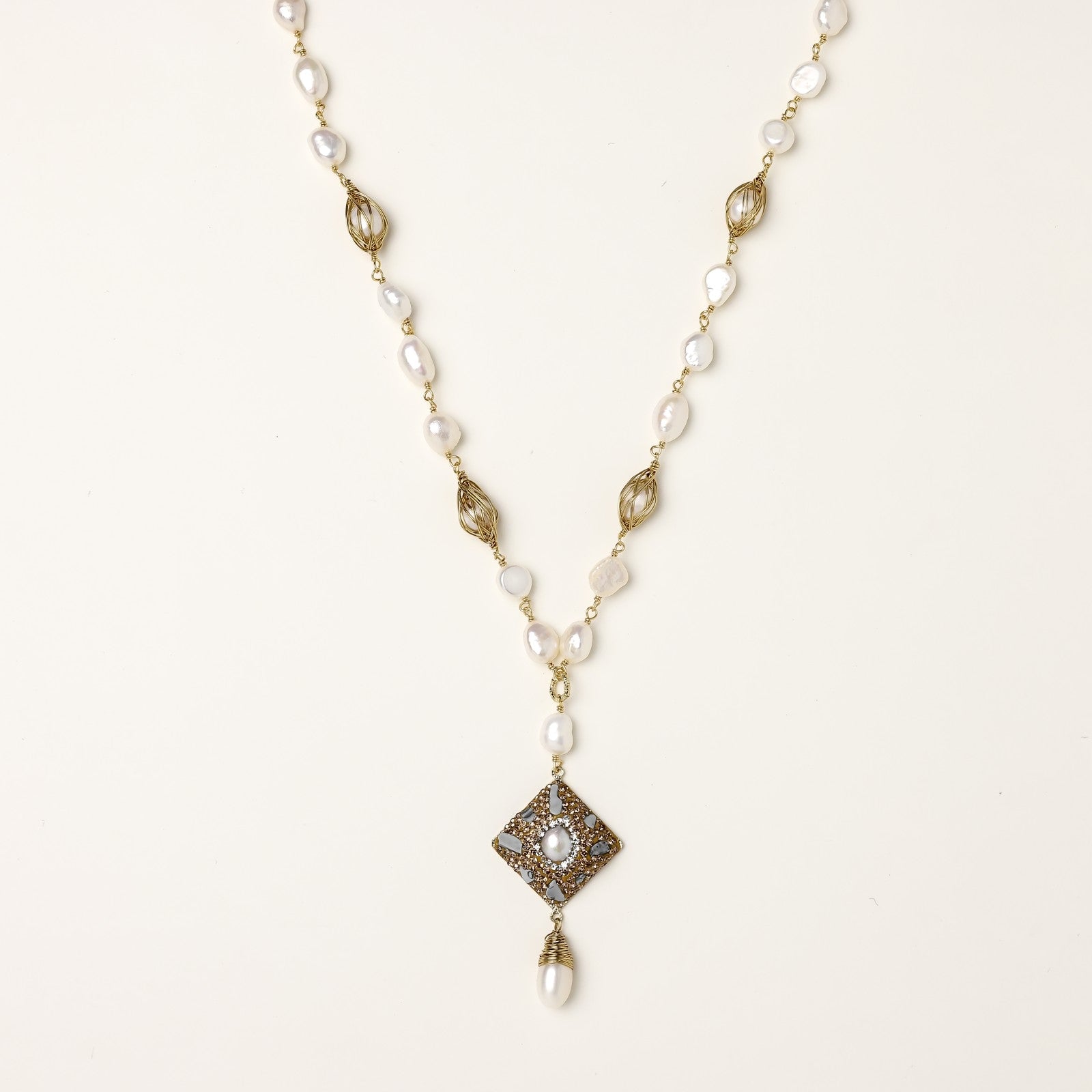 Elegant 14K gold plated necklace with freshwater pearls and ornate crystal diamond pendant on cream background.