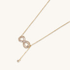 Delicate 14K gold plated infinity pendant with crystal accents on adjustable chain with small ball charm detail.