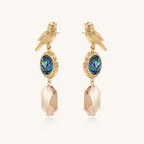 Gold-plated bird dangle earrings with iridescent abalone shell discs and champagne crystal drops on white background.