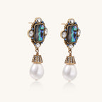 Gold-plated brass drop earrings featuring iridescent abalone shell centers, crystal accents, and white pearl drops.
