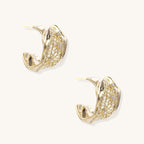 Close-up of gold-plated brass hoop earrings with geometric lattice pattern and sparkling zirconia stones