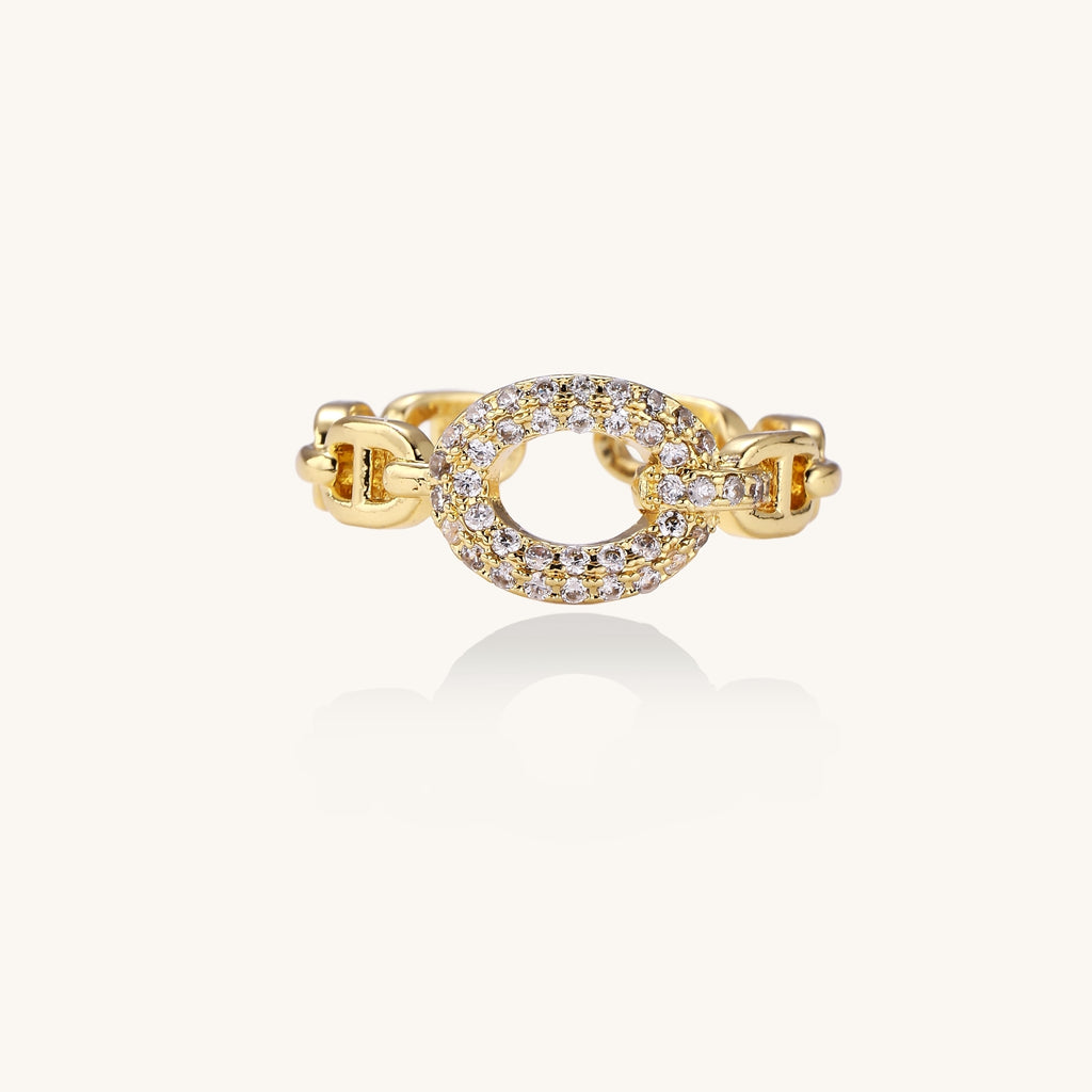 Gold-plated brass chain-link ring with cubic zirconia oval centerpiece, showing adjustable open-back design.