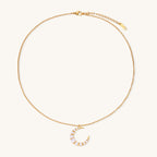 Delicate 18K gold plated necklace featuring crescent moon pendant with white shell pearl beads on neutral background.